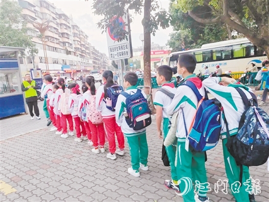 新会圭峰小学的学生有序排队，准备搭乘校园定制公交专线。