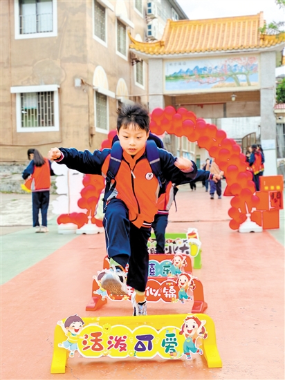 蓬江区荷塘镇联育小学学生跨过吉祥栏。