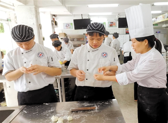 胡金铭（右一）在指导学生实训。