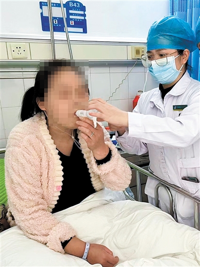 陈雪云教患者使用呼吸训练器。