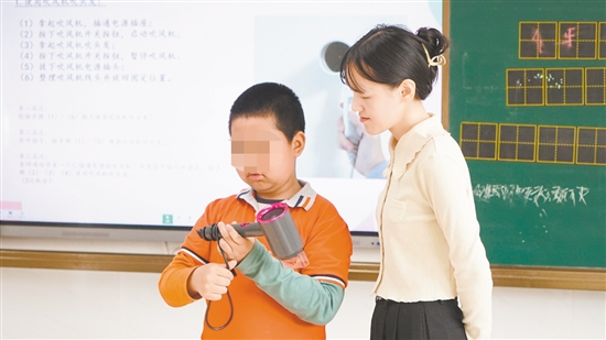 小明在老师指导下学习使用吹风机。