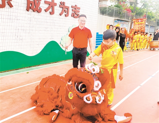 址山小学相关负责人和学生代表手持毛笔，饱蘸朱砂，为醒狮点睛。