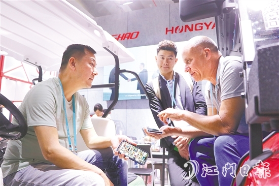 在江门鸿雅科技有限公司展位现场，来自美国迈阿密的客商正积极与企业商讨合作方式。刘淑君