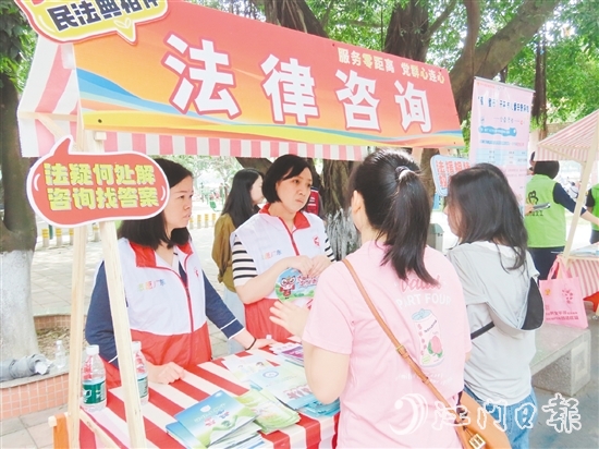 在法律援助摊位，司法系统党员志愿者耐心解答群众的法律咨询。