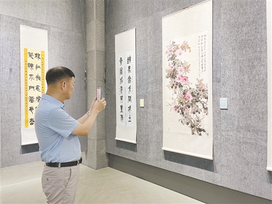 前来观展的市民用手机拍摄心仪作品。