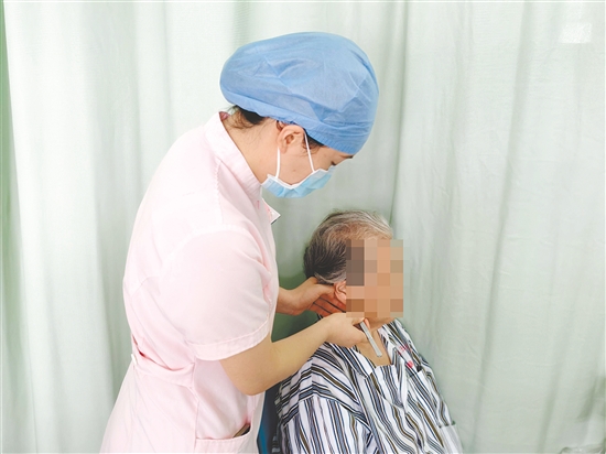 医护人员为患者进行中医外治疗法。 医护人员为患者进行中医外治疗法。