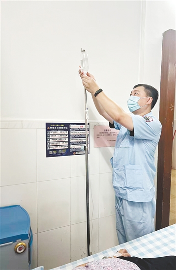 吴益浩核对药液、为患者调整输液流速。 吴益浩核对药液、为患者调整输液流速。