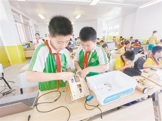 赛场上，小选手们全神贯注地进行机器人编程与调试。