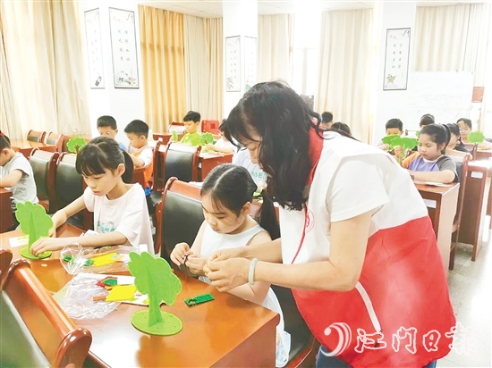 孩子们在志愿者的示范和指导下，精心制作“家庭树”。