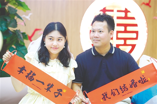 “520”迎来婚姻登记热潮，在蓬江区、江海区的婚姻登记处，新人拍照留念。江门日报记者