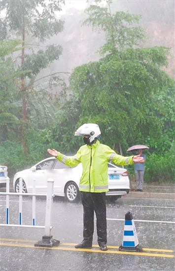 高考期间，交警在大雨中维持交通秩序。