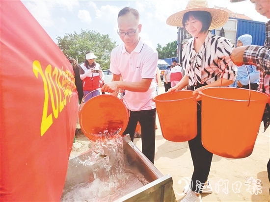 参与人员将鱼苗缓缓倒入放流槽。 参与人员将鱼苗缓缓倒入放流槽。