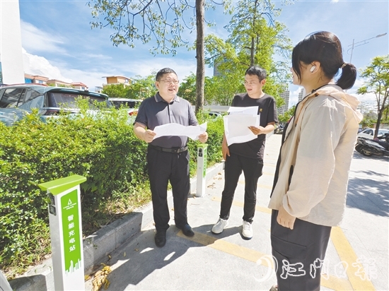 余中宏（左一）与同事一起查看“民生服务充电站”项目建设进度。