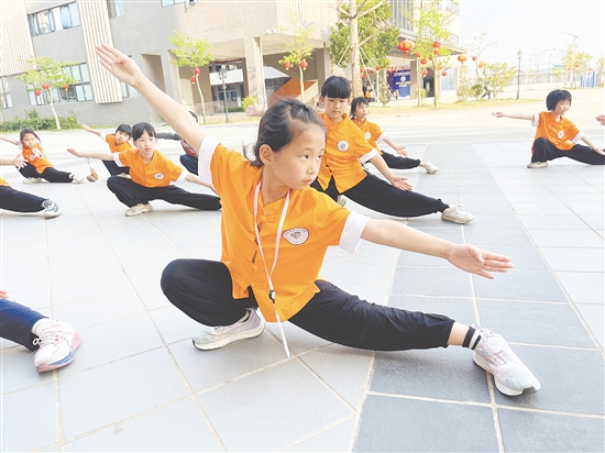 在武术队训练场，少年们目光如炬，马步扎实，出拳带风。