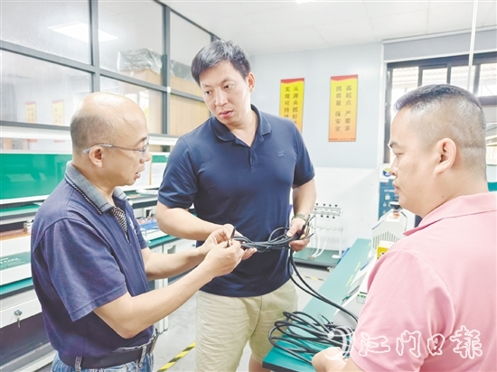 卢庆忠（中）与技术人员交流产品质量问题。
