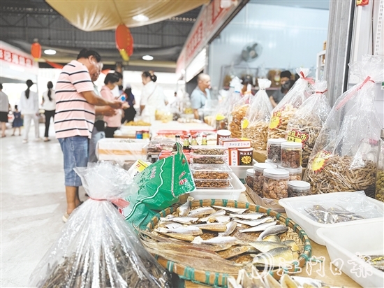 游客纷纷到海鲜特产市场挑选海味。