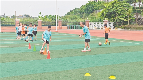 学生在教练的指导下学习足球技巧。 学生在教练的指导下学习足球技巧。