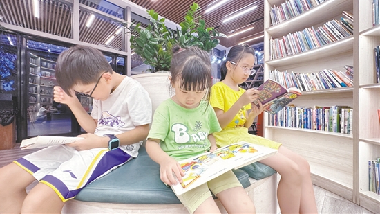 低年级学生围坐在书架旁阅读绘本。 低年级学生围坐在书架旁阅读绘本。