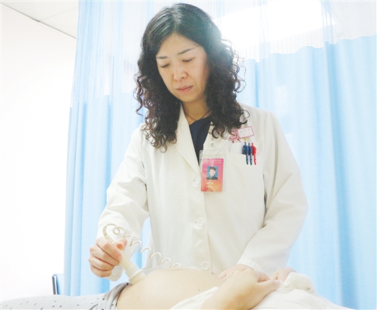 产科医生为孕妇检查胎儿状况。 产科医生为孕妇检查胎儿状况。