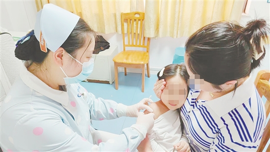 医护人员为孩子接种流感疫苗。 医护人员为孩子接种流感疫苗。