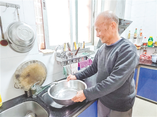 榕树村村民麦成建在厨房用干净的自来水清洗餐具。 榕树村村民麦成建在厨房用干净的自来水清洗餐具。