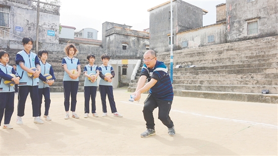 伍超明给孩子们演示垫球。