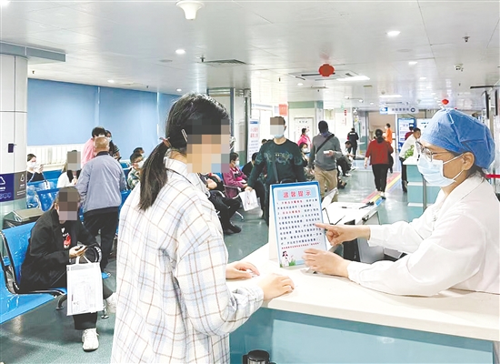 医护人员向市民介绍“一次挂号管一次就医流程”相关内容。