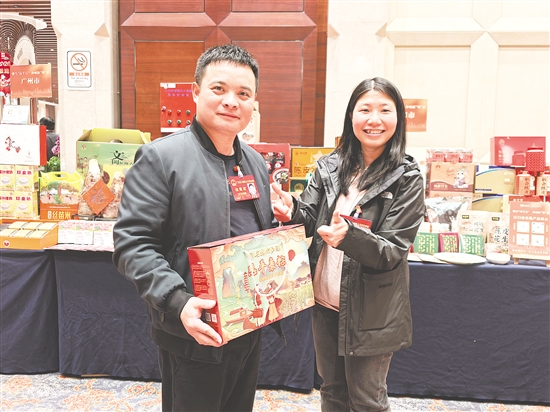 卢子策（左）热情推介家乡特色农产品。