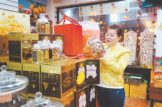 在新会传诚广陈皮商铺,负责人任霞在查看新会陈皮礼盒情况。 在新会传诚广陈皮商铺,负责人任霞在查看新会陈皮礼盒情况。