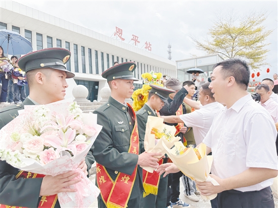 迎接队伍工作人员为退役军人佩戴“光荣返乡”绶带，送上鲜花。