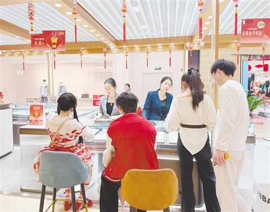 顾客在金店挑选心仪的金饰品。
