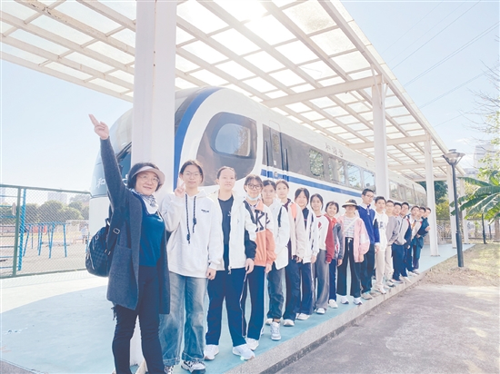 梁峻华（左一）带领学生在五邑大学交通轨道实训基地研学。