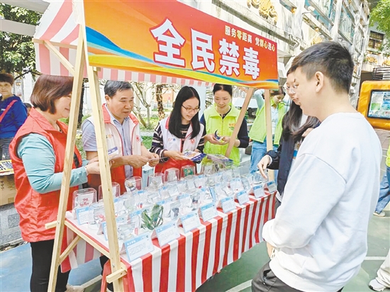 工作人员向群众派发宣传资料，增强群众拒毒意识。