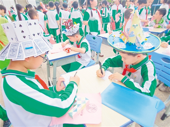 学生们头戴各具特色的数学元素帽，穿梭于各个摊位间，在趣味游戏中展开“头脑风暴”。