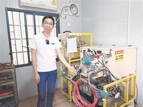 黄伟盛向记者介绍水泵的结构和功能。