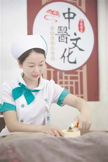 医护人员正在实施中医外治法。 医护人员正在实施中医外治法。