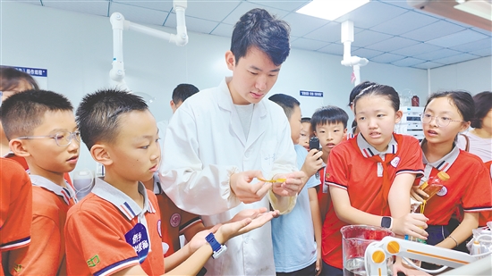 学生在导师的帮助下操作科学实验。