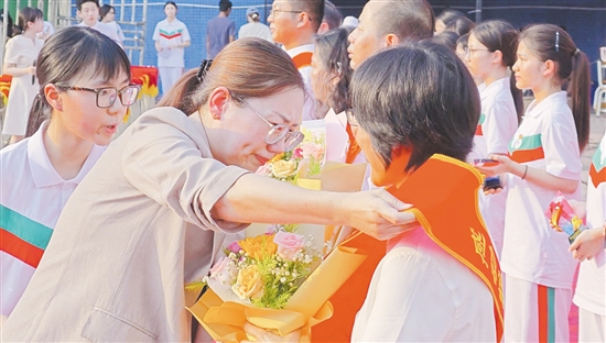 田良荣为教师佩戴“感动鹤华十大人物”绶带。
