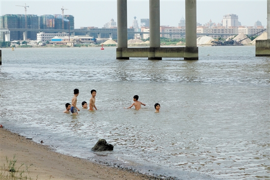江门港旁中江高速高架桥下,几名小孩正在戏水,没有大人在旁看护.