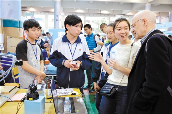 江门一职学生向外国教授介绍他们的参赛作品.