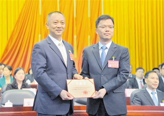 新会区委书记文彦向新当选的新会区区长梁明建颁发证书. 张奕维 摄