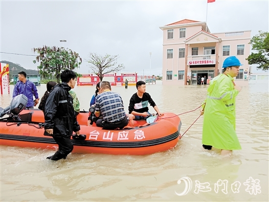 台山市赤溪镇长安村驻村第一书记谷文强拉着橡皮艇涉水转移群众。