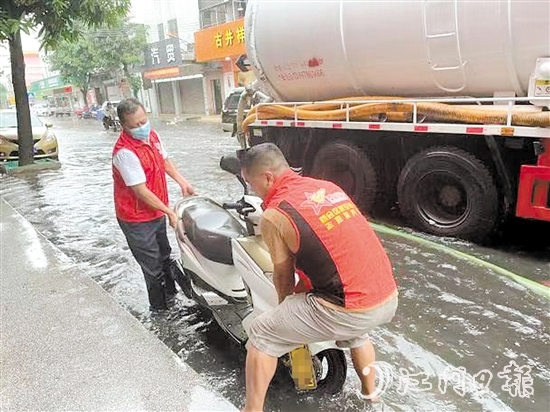 新会区大鳌镇退役军人志愿者到低洼地带排查，将一辆被水泡着的车辆抬到高处。