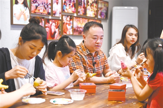 镇濠泥鸡制作技艺代表性传承人冯永勇在赤坎华侨古镇“镇濠泥鸡非遗文化馆”参加“非遗亲子体验活动”，宣传非遗文化。