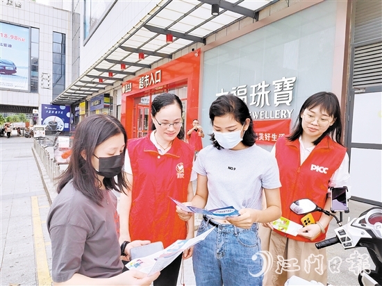 恩平人保财险工作人员向群众派发宣传折页，普及金融知识。