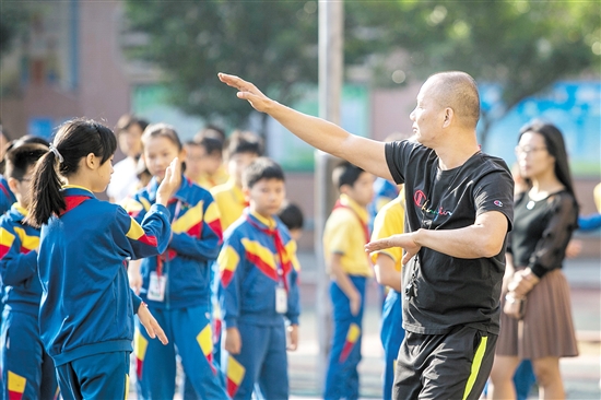 沙坪街道第二小学教师指导学生学习咏春招式。