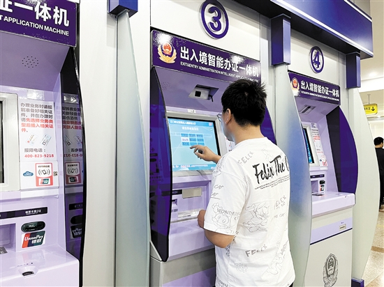 市民在出入境智能签注一体机自助办理港澳通行证再次签注。