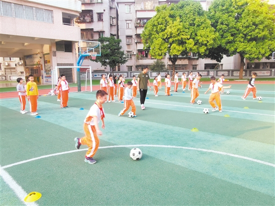 沙坪一小学生在老师的带领下开展足球训练。