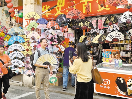 “文旅商”商业发展模式越来越“香”。图为游客在长堤历史文化街区拍照留念。