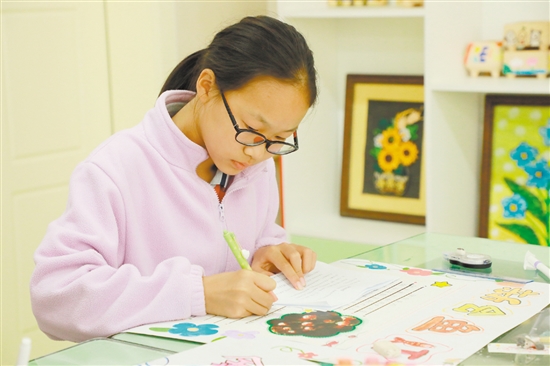 里仁小学学生正在绘制非遗海报。